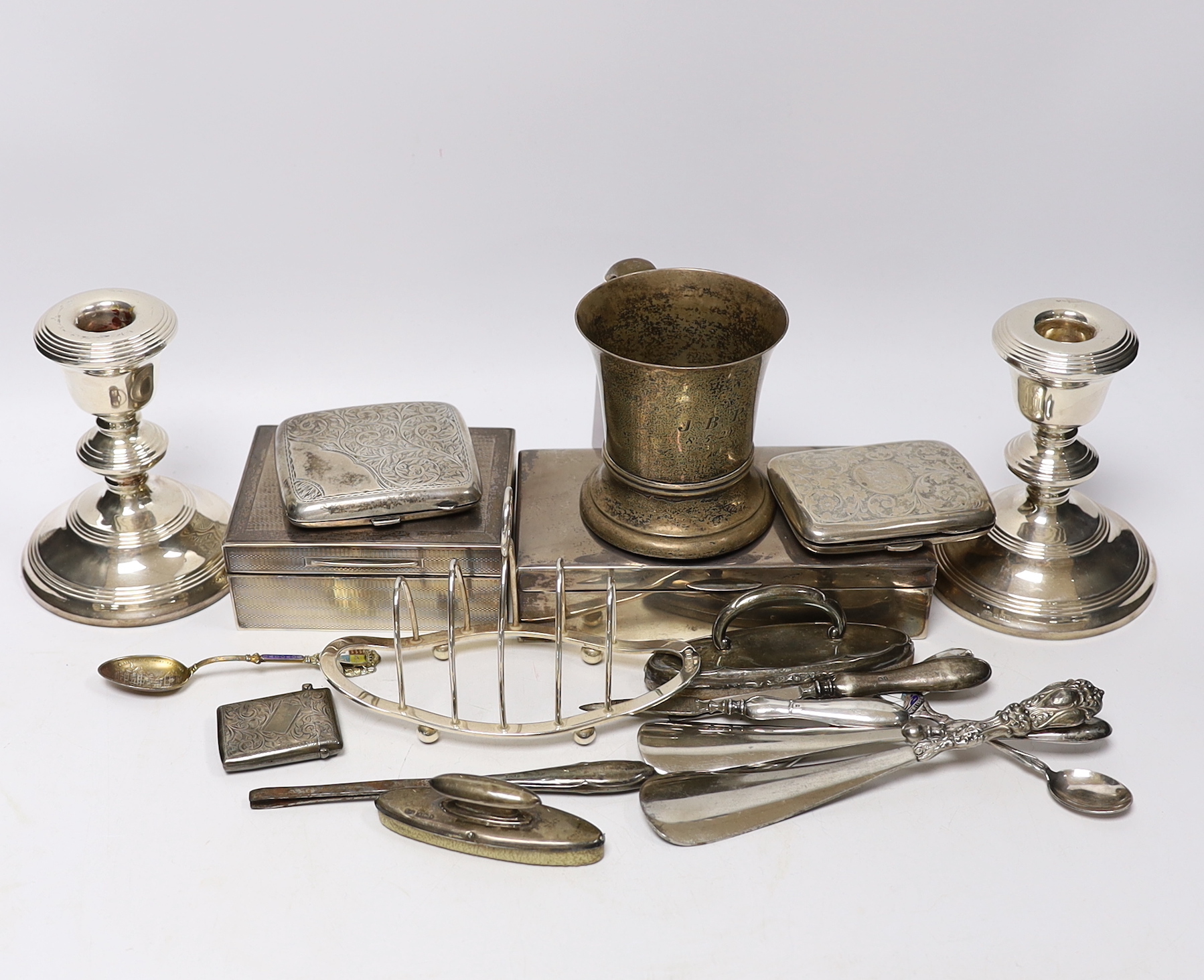 A George V silver christening mug by Charles Edwards, London, 1912, 86mm, together with two silver mounted cigarette boxes, two silver cigarette cases, a pair of silver mounted dwarf candlesticks, a silver vesta case, a